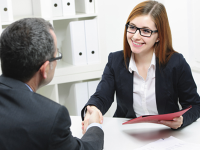 A man and woman shaking hands during a business meeting