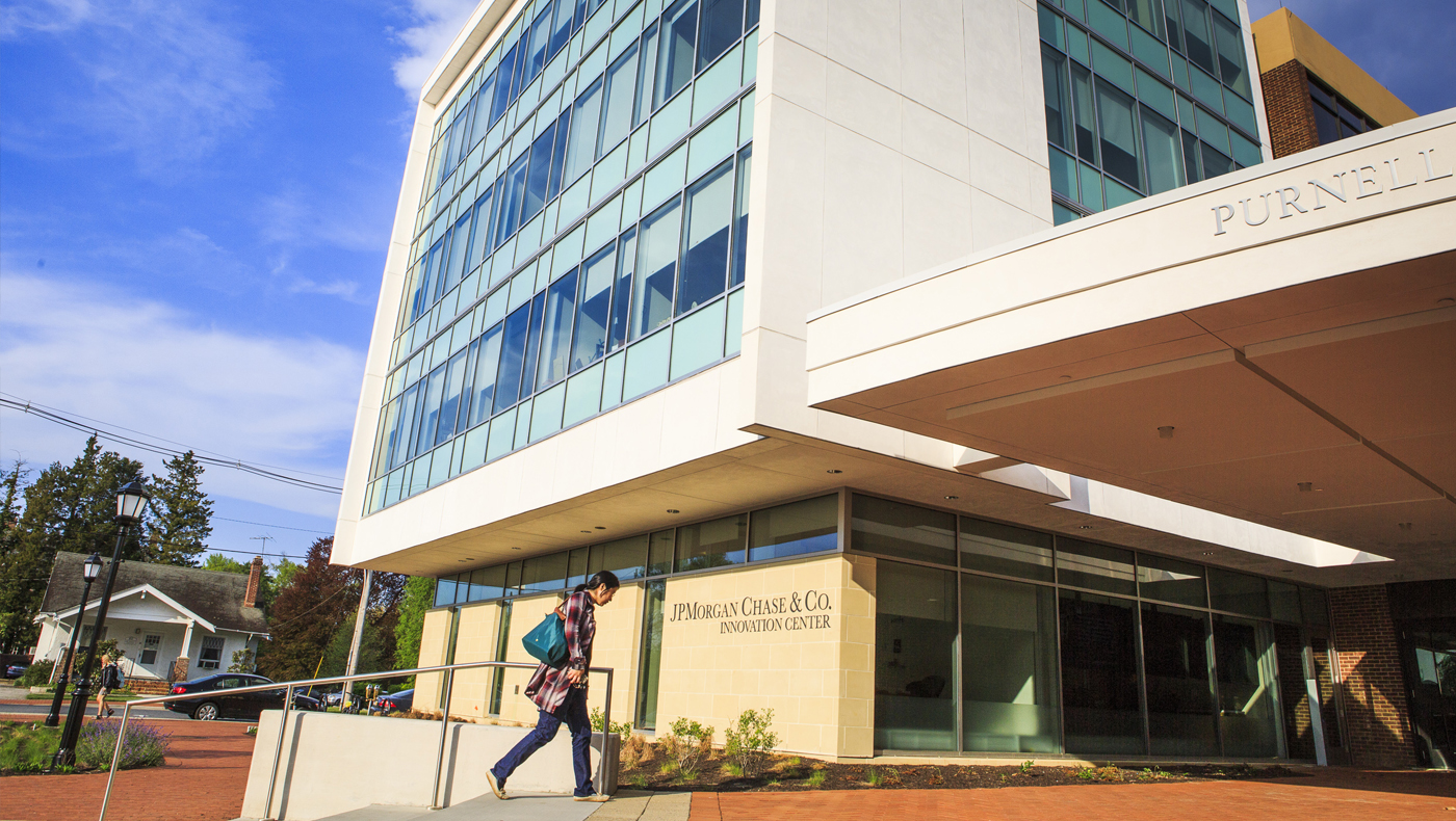 A student walking towards Purnell Hall.