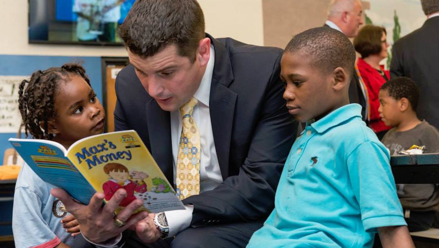 Professor Asarta reads to children.