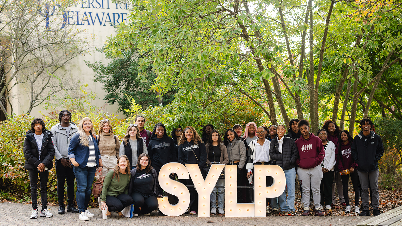 Group of students around SYLP sign outside Clayton Hall.