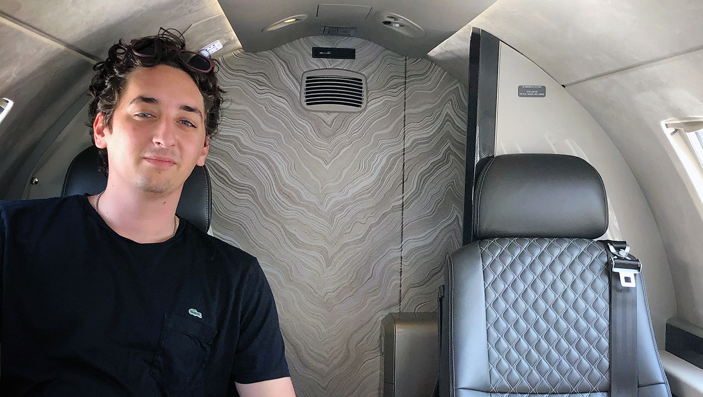 Alexander Pugliese poses for a photo while sitting on a plane.