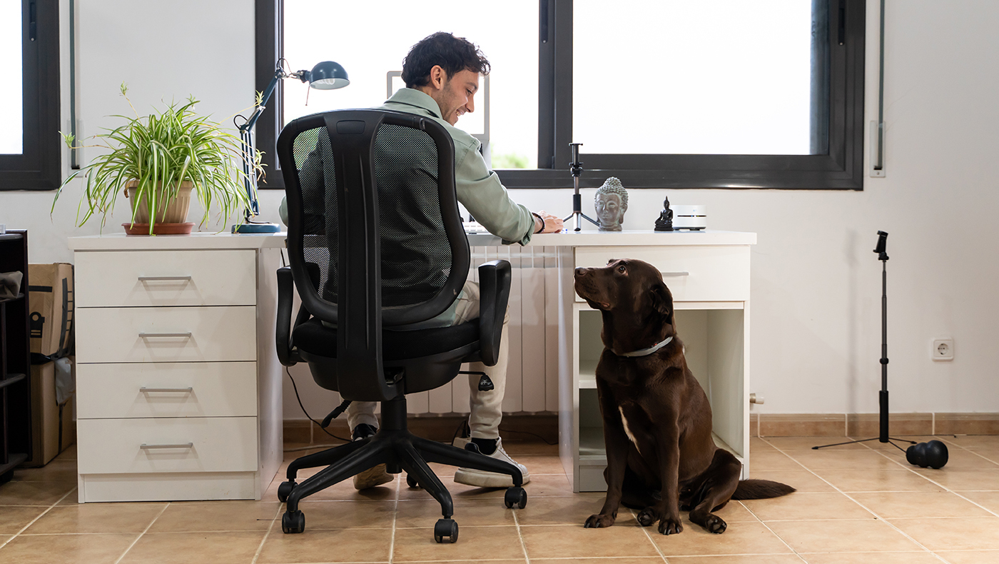 At home worker interacting with dog