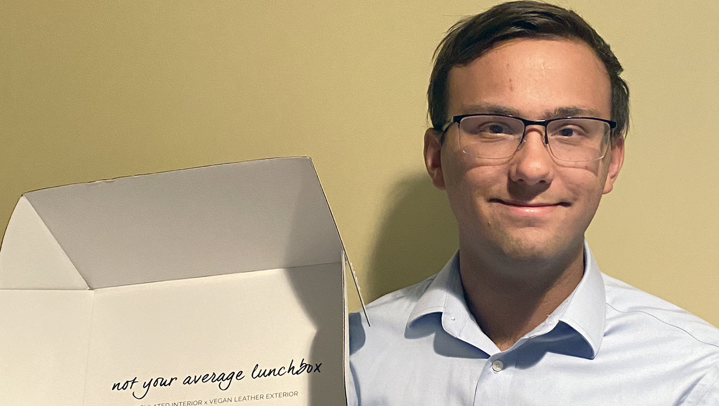 Eric Albiez poses for a photo with a box from his internship.