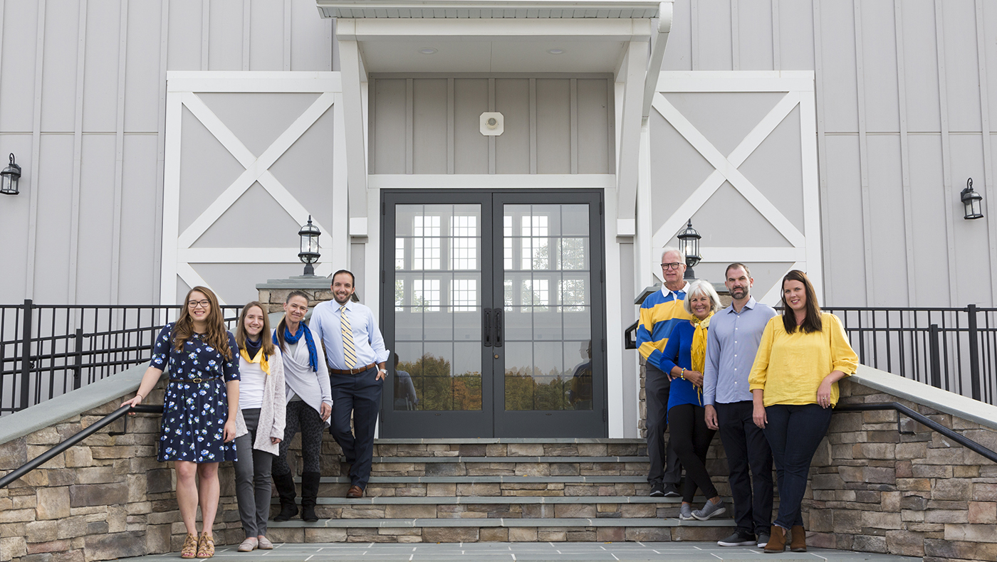 Blue Hens working on Rosewood Farms pose for a photo in front of one of their buildings.
