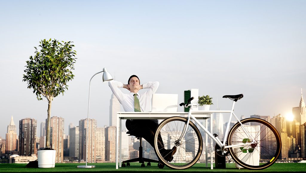 Stock image of man sitting at desk with bike in front